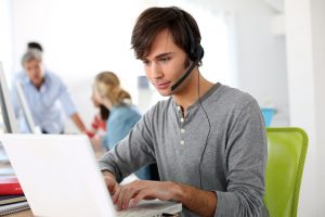 teenager at computer with headset on